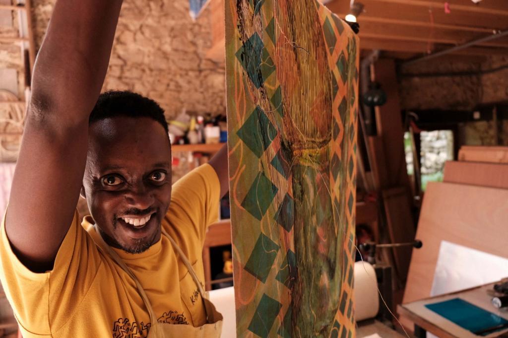 Evans Mbugua tenant une de ses nouvelles oeuvres créé à l'Atelier le Grand Village. Avec l'aimable autorisation de l'Atelier le Grand Village.